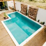 blue swimming pool near green trees during daytime